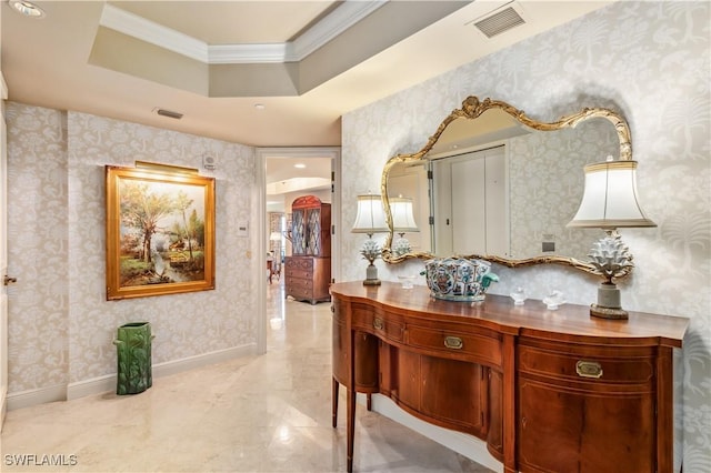 corridor featuring wallpapered walls, baseboards, visible vents, ornamental molding, and a tray ceiling