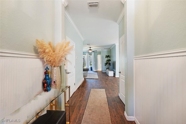 corridor featuring dark wood-style floors, visible vents, ornamental molding, and wainscoting