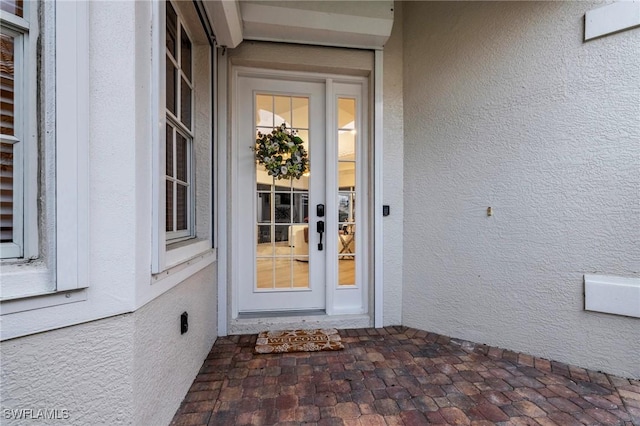 entrance to property featuring stucco siding