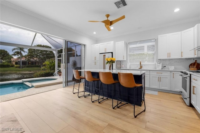 kitchen with a center island, white cabinetry, and stainless steel range