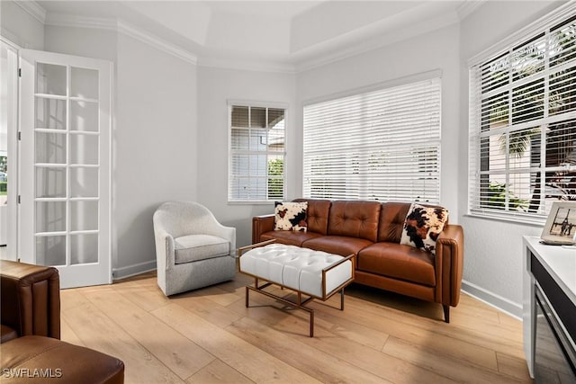 living room with baseboards, ornamental molding, and light wood-style floors