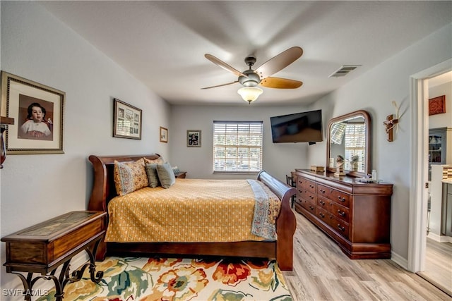 bedroom with light wood-style flooring, visible vents, ceiling fan, and baseboards