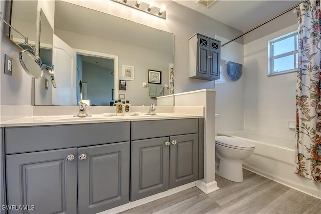 bathroom with toilet, shower / tub combo, a sink, and wood finished floors