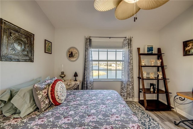 bedroom featuring light wood-type flooring, a ceiling fan, and baseboards