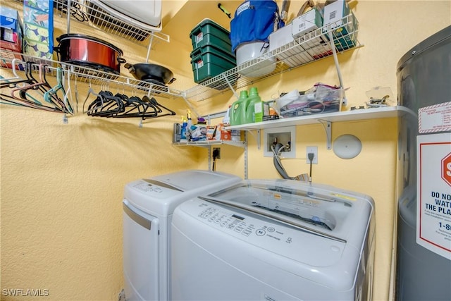 clothes washing area with laundry area, washer and clothes dryer, and gas water heater