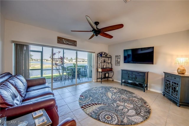 living room with light tile patterned flooring, a ceiling fan, and baseboards