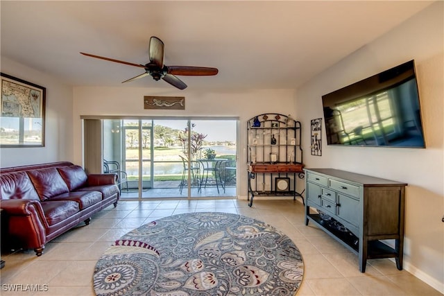 living room featuring light tile patterned floors, ceiling fan, and baseboards