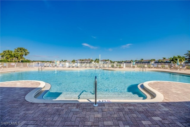 community pool featuring a patio area and fence