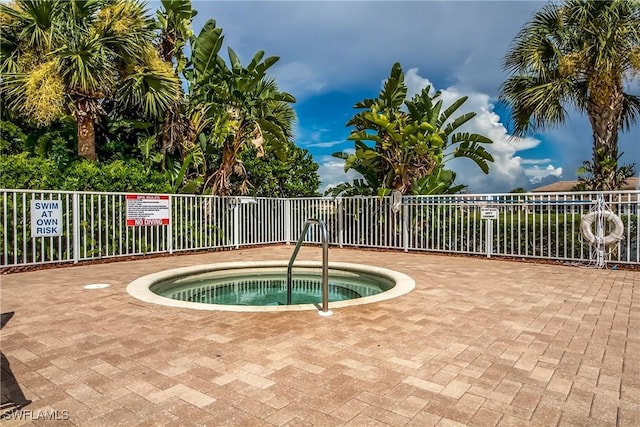 view of pool featuring a hot tub and fence