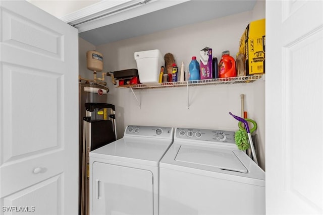 laundry room featuring laundry area, washer and clothes dryer, and strapped water heater