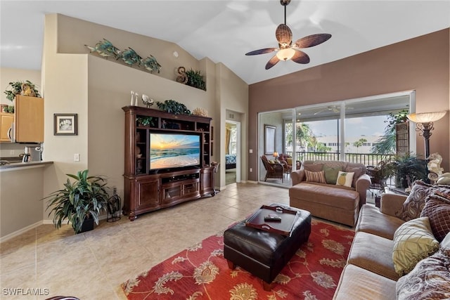 living area featuring lofted ceiling, ceiling fan, light tile patterned floors, and baseboards