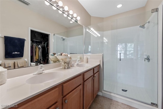 full bathroom featuring tile patterned flooring, visible vents, a walk in closet, and a sink