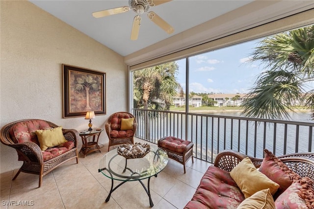 sunroom featuring a ceiling fan, a water view, and vaulted ceiling