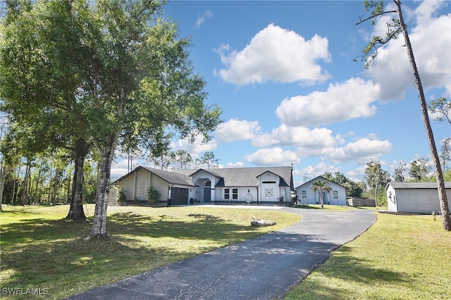 view of front of house with aphalt driveway, a residential view, and a front lawn