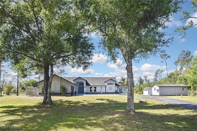 view of front of property featuring a front yard and an outdoor structure