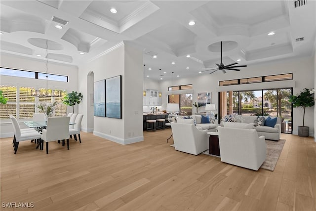 living room featuring baseboards, visible vents, light wood finished floors, and a high ceiling