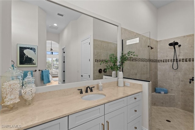 bathroom with visible vents, walk in shower, and vanity