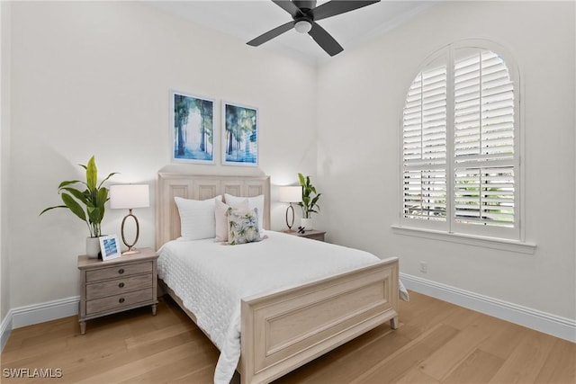 bedroom with light wood-type flooring, baseboards, and a ceiling fan