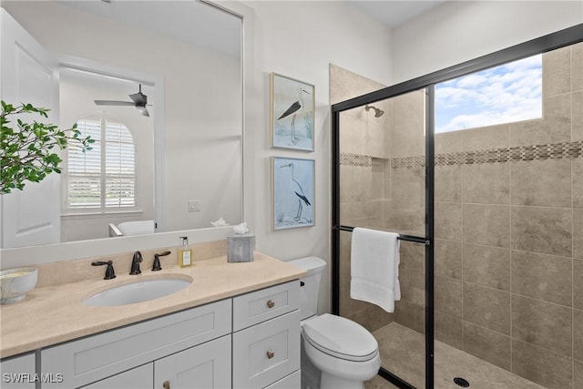 full bath featuring ceiling fan, a shower stall, toilet, and vanity