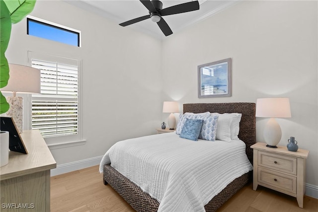 bedroom with light wood-style flooring, baseboards, ceiling fan, and crown molding