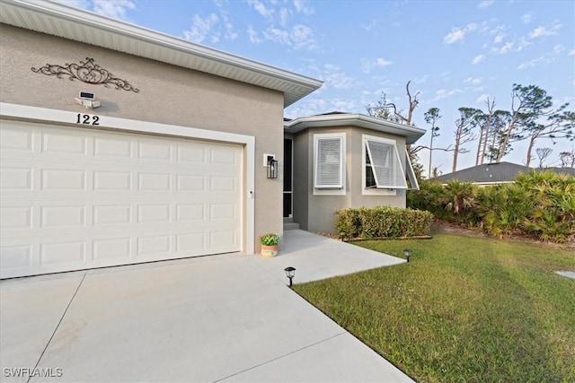 ranch-style home featuring an attached garage, a front yard, concrete driveway, and stucco siding