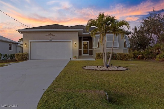 ranch-style home with a front lawn, driveway, an attached garage, and stucco siding