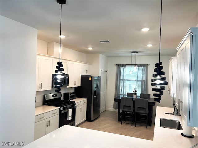 kitchen with pendant lighting, light countertops, visible vents, white cabinets, and black appliances