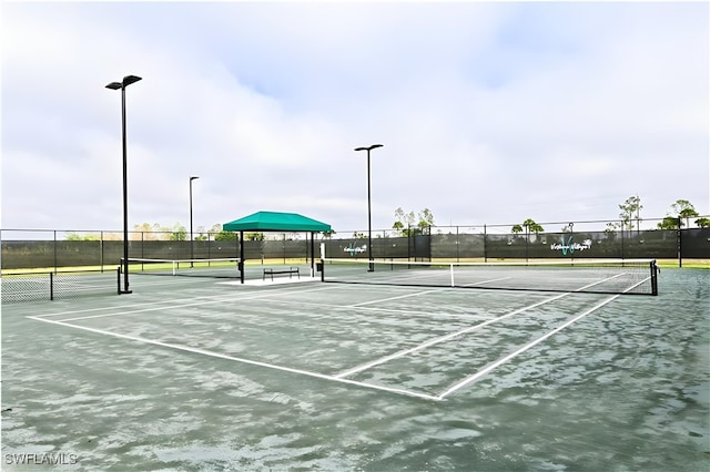 view of tennis court featuring fence