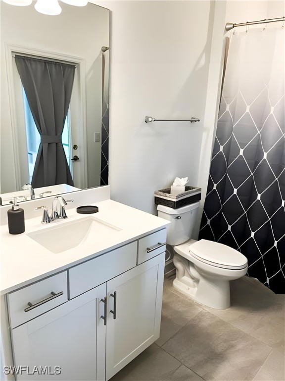 full bathroom featuring toilet, curtained shower, and vanity