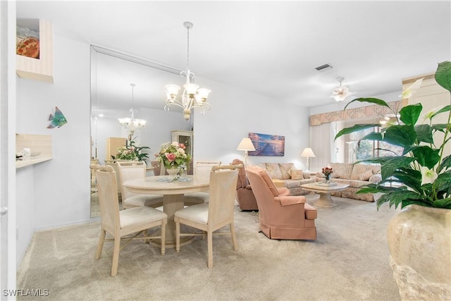 carpeted dining room featuring visible vents and ceiling fan with notable chandelier