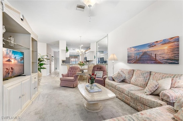 living area featuring light carpet, a chandelier, and visible vents