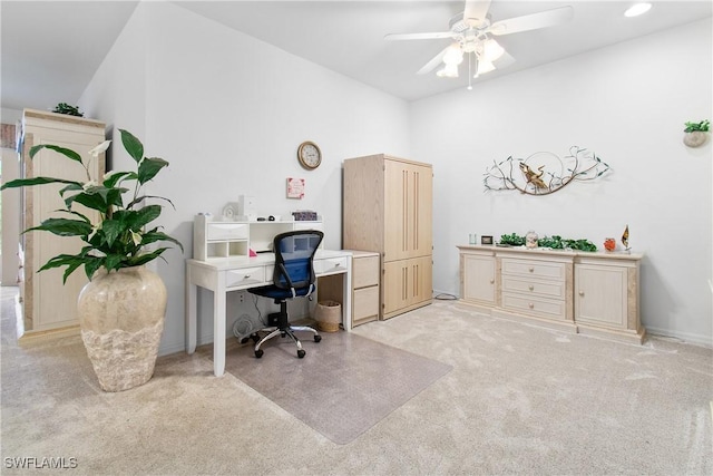 home office featuring lofted ceiling, light carpet, and ceiling fan