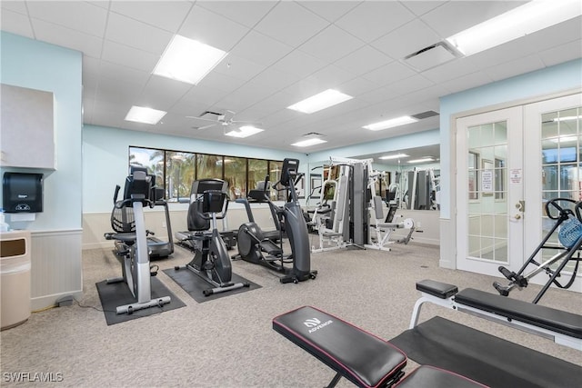 workout area featuring visible vents, french doors, wainscoting, and a paneled ceiling