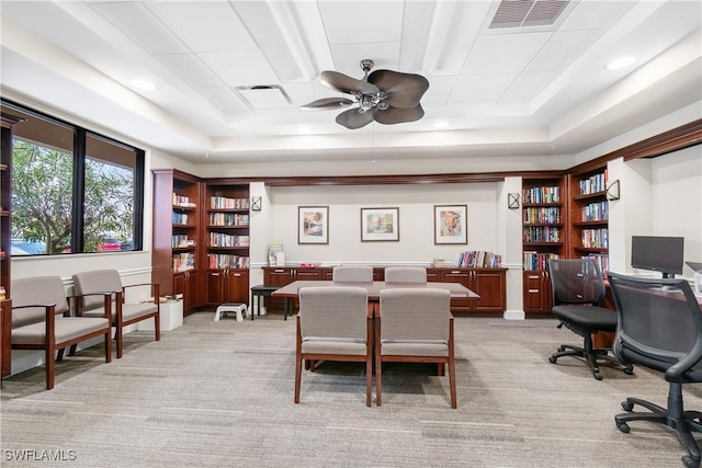 office featuring a tray ceiling, visible vents, and light carpet