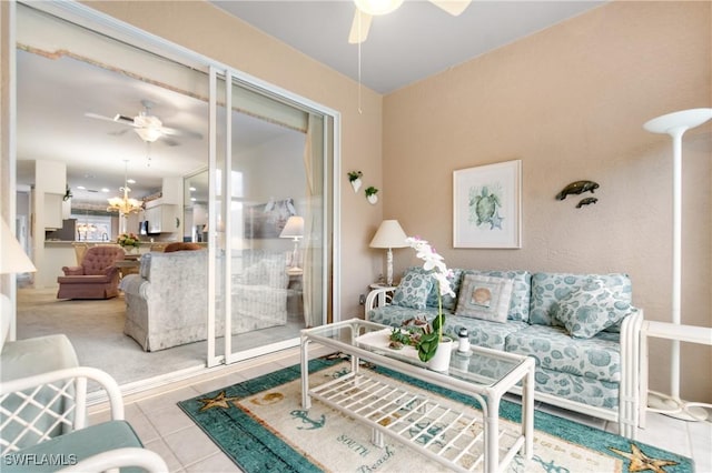 living room featuring tile patterned flooring and ceiling fan with notable chandelier