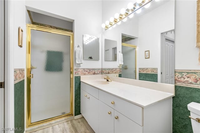 full bath featuring wainscoting, tile walls, a shower stall, and vanity