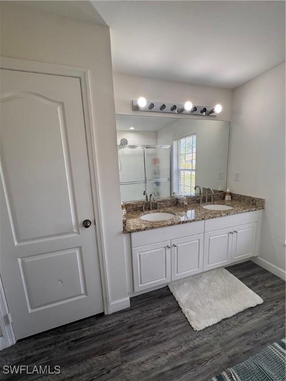 full bath featuring wood finished floors, a stall shower, and a sink