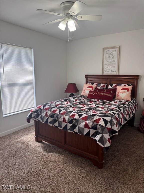 carpeted bedroom featuring ceiling fan and baseboards