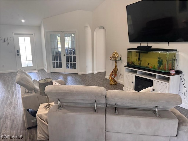 living room featuring baseboards, arched walkways, dark wood finished floors, vaulted ceiling, and recessed lighting