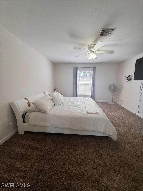 bedroom featuring a ceiling fan, visible vents, dark carpet, and baseboards