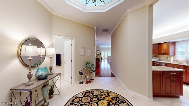 hallway featuring light tile patterned floors, ornamental molding, and baseboards