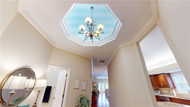 hall featuring plenty of natural light, a sink, visible vents, and crown molding