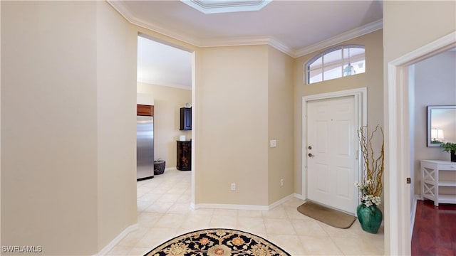 entrance foyer featuring baseboards, crown molding, and light tile patterned flooring