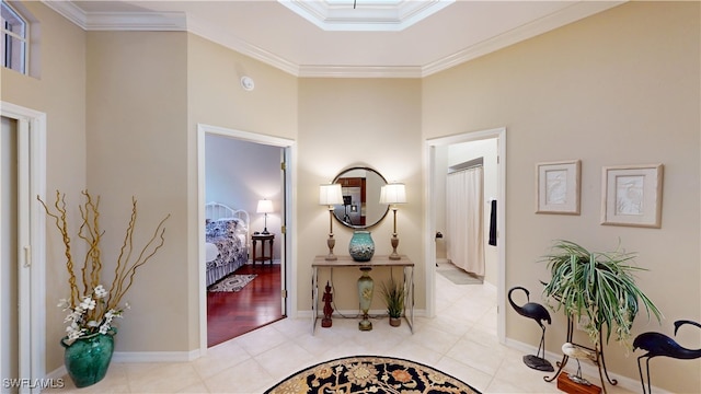 hallway featuring light tile patterned floors, baseboards, and crown molding