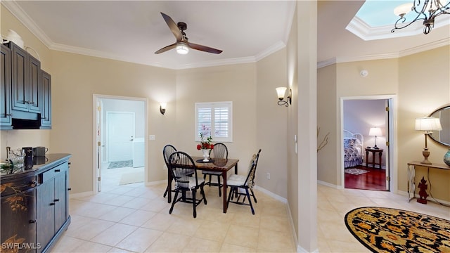 dining room with light tile patterned floors, ornamental molding, ceiling fan with notable chandelier, and baseboards