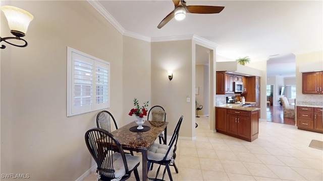 dining room featuring light tile patterned floors, a ceiling fan, baseboards, and crown molding