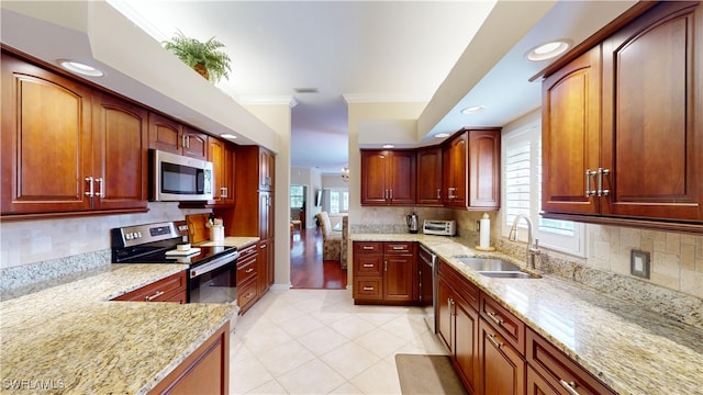 kitchen with light stone counters, crown molding, visible vents, appliances with stainless steel finishes, and a sink