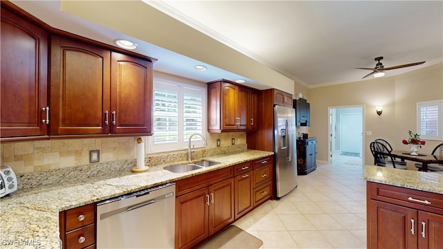 kitchen featuring crown molding, decorative backsplash, appliances with stainless steel finishes, a sink, and light stone countertops