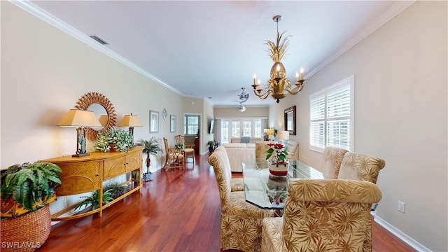 dining room with an inviting chandelier, crown molding, baseboards, and wood finished floors