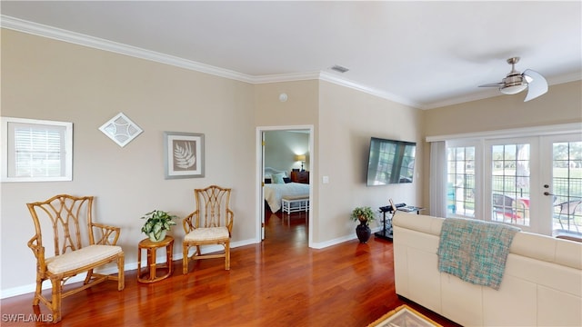 living area with visible vents, baseboards, a ceiling fan, dark wood finished floors, and crown molding